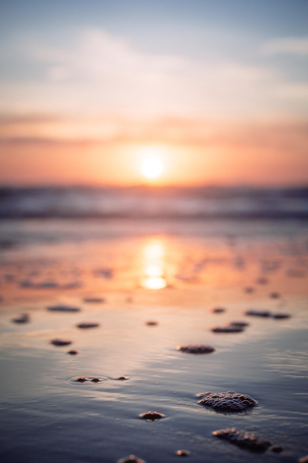 A group of retirees sitting on a beach, enjoying the sunset.