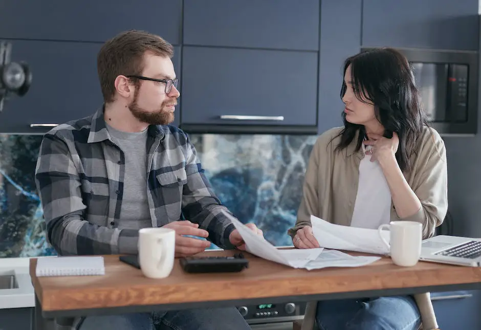 A couple sitting at a table together, looking at financial documents and discussing a spousal IRA contribution limit for the year.